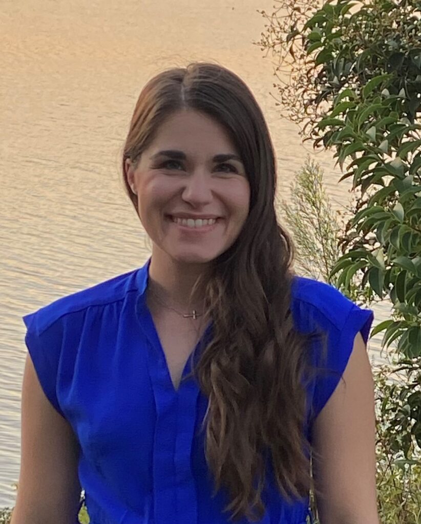 Rebekah Young, female with long brown hair wearing a bright blue dress